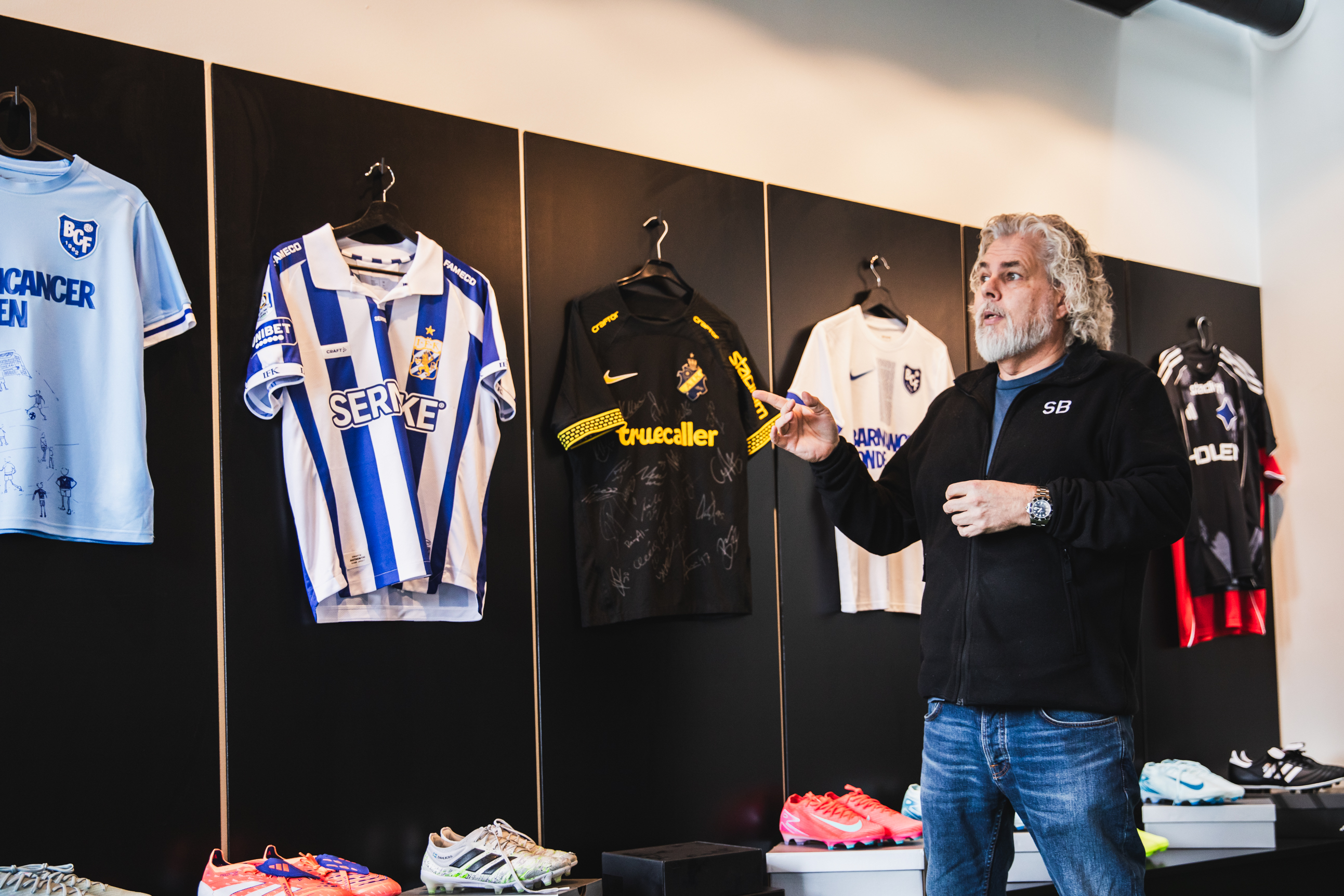 Foto på Brandtowns vd Stephan Burman som visar ett urval av matchtröjor.