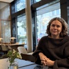 Frida Palmliden sittandes i konferenslokal.