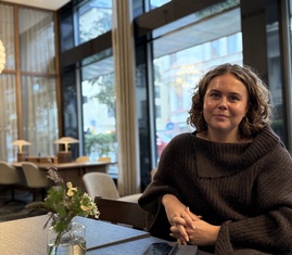 Frida Palmliden sittandes i konferenslokal.