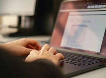 Person som skriver på en laptops tangentbord.