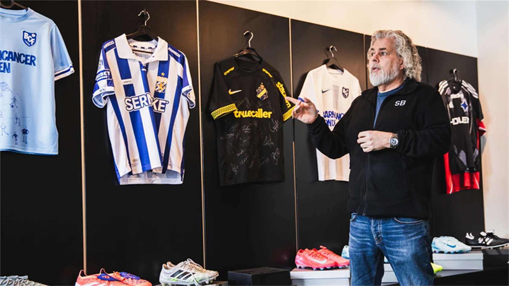 Foto på Brandtowns vd Stephan Burman som visar ett urval av matchtröjor.