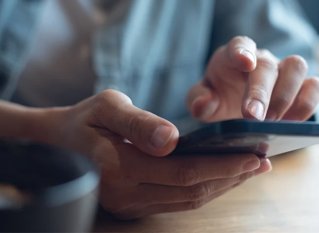 Bild på en hand som håller en smartphone.