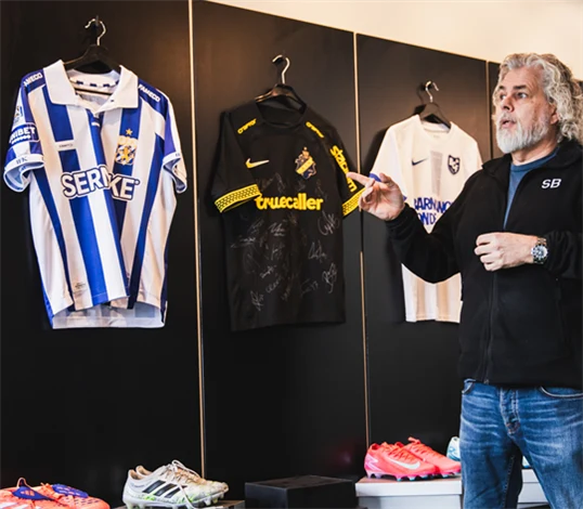 Foto på Brandtowns vd Stephan Burman som visar ett urval av matchtröjor.